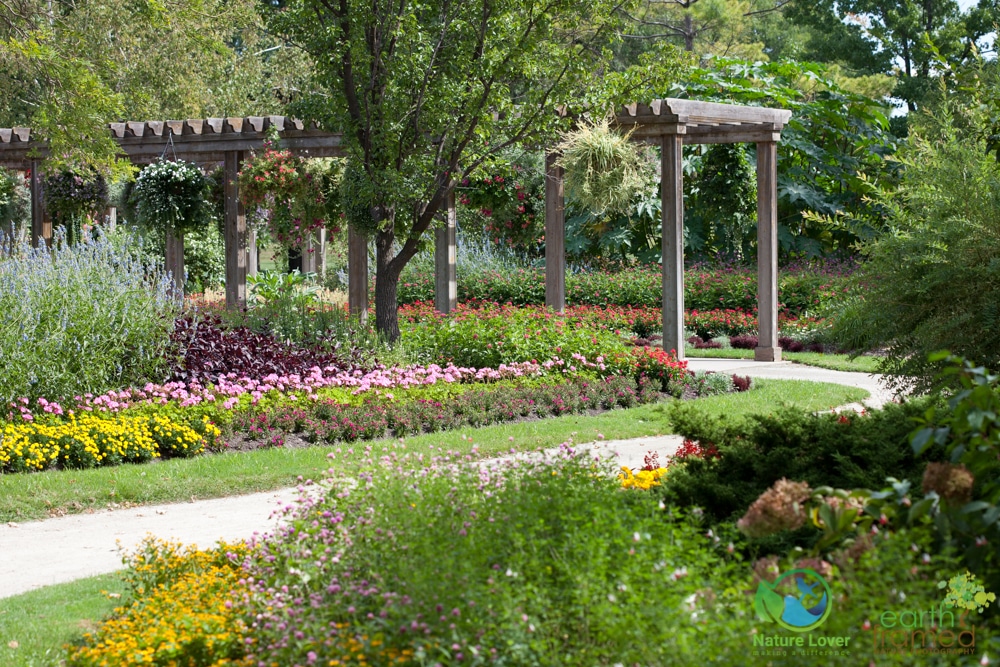 Wooden garden entrance surrounded by trees and flowers at Germain Park