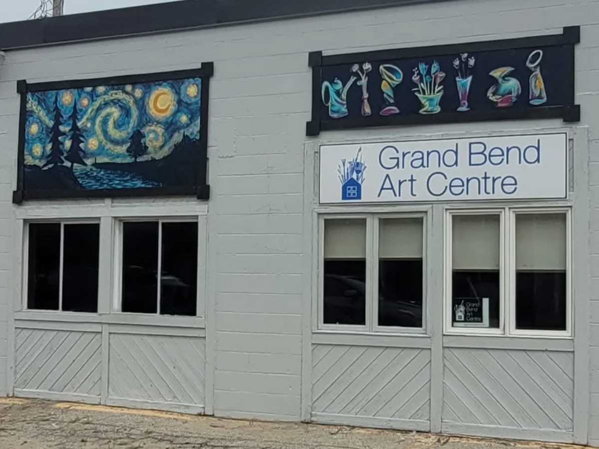 The front of the Grand Bend Art Centre on Municipal Drive, its sign under a Starry Night mural and a row of painted vases