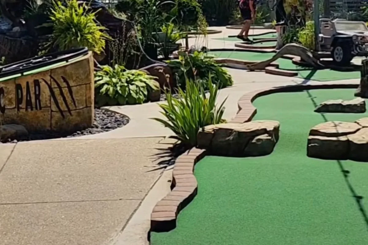 A mini golf course on Main Street in Grand Bend, green fairways winding between rocks and planted beds