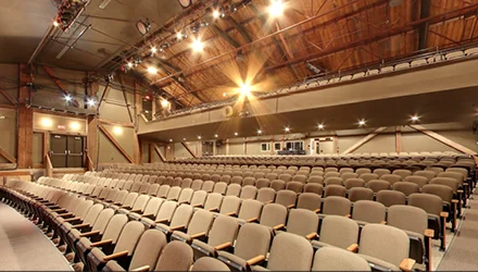 The empty auditorium of the Huron Country Playhouse, rows of seats under the stage lights