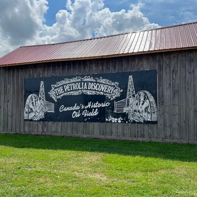 A painted sign on a barn wall reading The Petrolia Discovery, Canada's Historic Oil Field