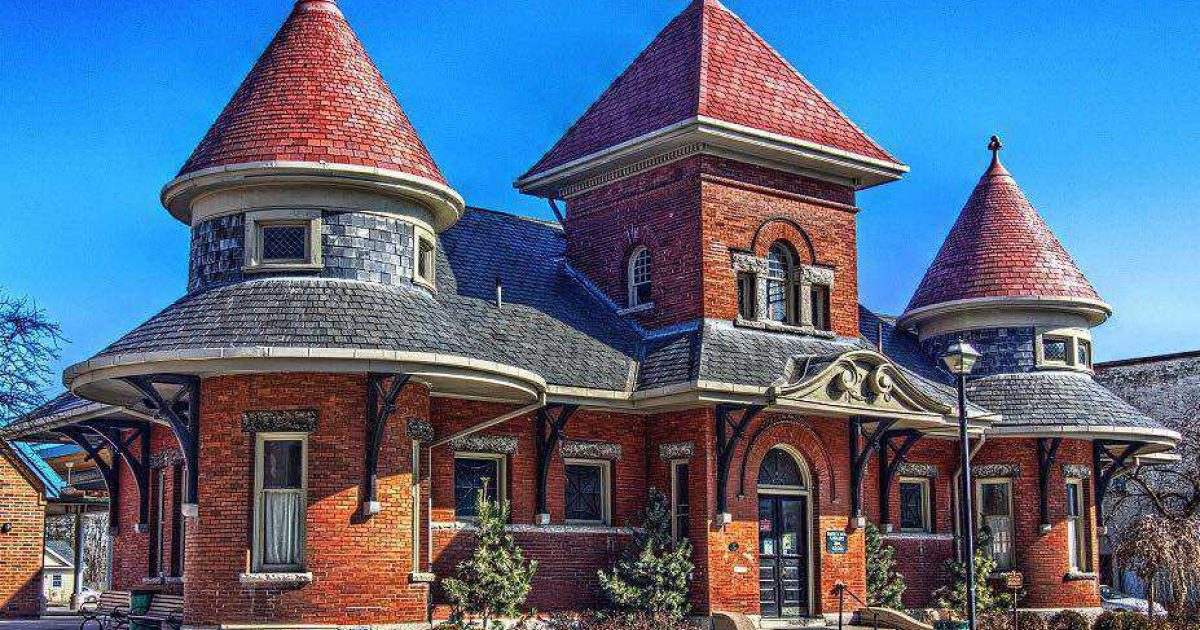 Petrolia Library, a red-brick former railway station with conical turrets and a slate roof under a blue sky