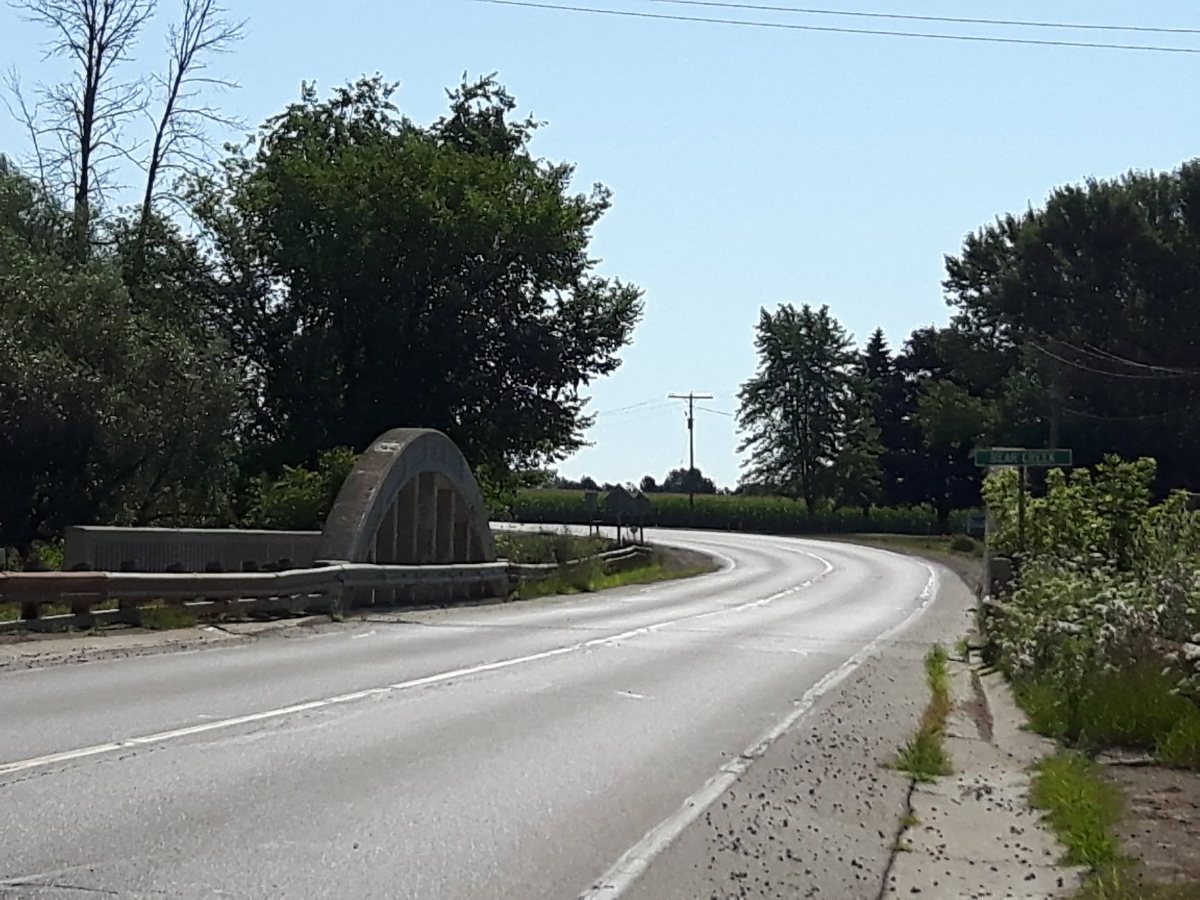 Egremont Road curving over a concrete arched bridge at Warwick Village