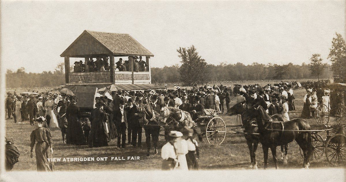 A vintage photograph captioned View at Brigden Ont Fall Fair, with horses, buggies and a crowded grandstand