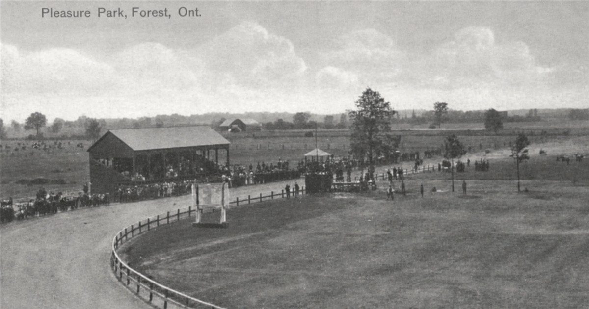 A vintage black-and-white postcard titled Pleasure Park, Forest, Ont., showing the fairground race track and a wooden grandstand