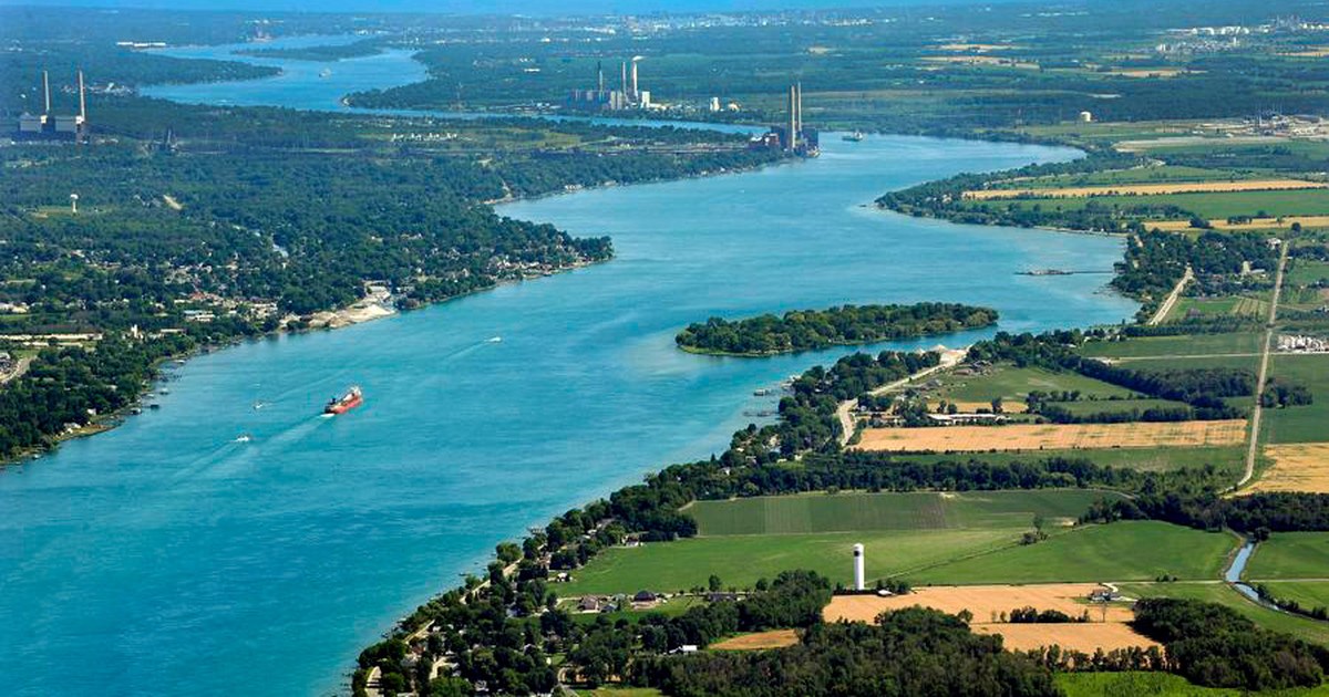 Aerial view of the St. Clair River winding through St. Clair Township, with a freighter moving upriver
