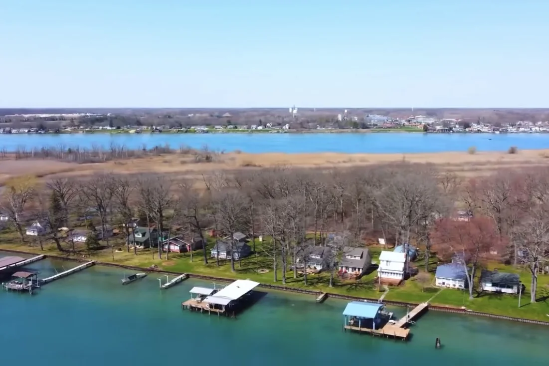 Cottages, docks and boathouses along the Stag Island shore in early spring, seen from the air